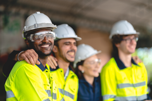 smiling construction workers wearing hard hats and safety glasses